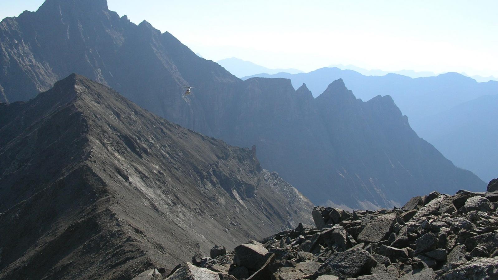 Incoming helicopter - looking north at Butress Peak from ridge between REE Yippie and REE Base-Metal anomalies at the Ice River Complex Project