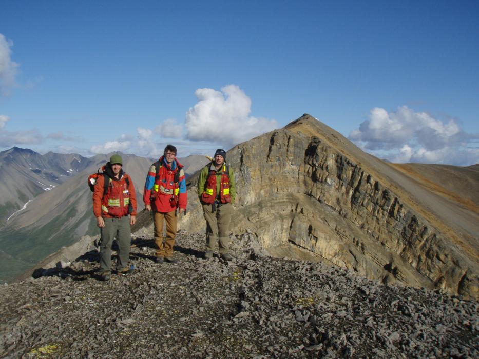 Geologists and huge moiuntain fold Geologist posing in the foreground of a huge fold in the Mackenzie Mountains